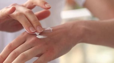 El kremi. Masaj hareketleriyle cildine el kremi sür, yakın plan. Yaşlanma önleyici kozmetik. Kadınların el bakımı