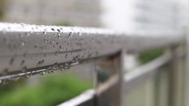 Yağmurda balkon korkulukları, seçici odaklanma. Balkon korkuluklarında yağmur damlaları, ıslak balkon. Balkon korkuluklarına düşen yağmur damlaları. Su damlası