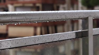 Yağmurda balkon korkulukları, seçici odaklanma. Balkon korkuluklarında yağmur damlaları, ıslak balkon. Balkon korkuluklarına düşen yağmur damlaları. Su damlası