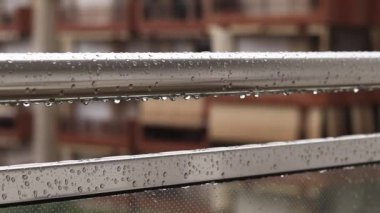 Yağmurda balkon korkulukları, seçici odaklanma. Balkon korkuluklarında yağmur damlaları, ıslak balkon. Balkon korkuluklarına düşen yağmur damlaları. Su damlası