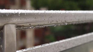 Yağmurda balkon korkulukları, seçici odaklanma. Balkon korkuluklarında yağmur damlaları, ıslak balkon. Balkon korkuluklarına düşen yağmur damlaları. Su damlası