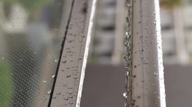 Yağmurda balkon korkulukları, seçici odaklanma. Balkon korkuluklarında yağmur damlaları, ıslak balkon. Balkon korkuluklarına düşen yağmur damlaları. Su damlası