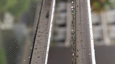 Yağmurda balkon korkulukları, seçici odaklanma. Balkon korkuluklarında yağmur damlaları, ıslak balkon. Balkon korkuluklarına düşen yağmur damlaları. Su damlası