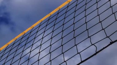 Plaj voleybol ağı yakın çekim. Plajda gökyüzüne karşı bir voleybol ağı parçası. Spor, plaj voleybolu. Aktif eğlence konsepti. Geçmişi. Sarı ağın ayrıntıları. Spor sahası