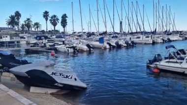 Salou, İspanya - 20 Eylül 2024: Esportiu de Salou Limanı. Bir sürü küçük tekne ve yatı olan küçük bir liman. Güneşli bir günde limanda yatlar. İskeleye demirlemiş küçük tekneler. Motorlu ve direkli tekneler