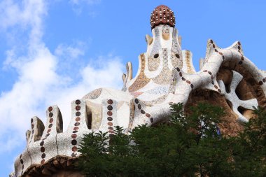 Barselona, İspanya - 19 Eylül 2024: Park Guell, Antonio Gaudi. Park Guell, Barcelona 'daki binanın çatısında. Masal evi.