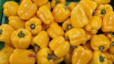 Dükkandaki tezgahta sarı biberler var. Süpermarkette plastik kutulardaki biberler. Yemek pişirmek için. Bir grup taze organik sarı tatlı biber. Sağlıklı gıda ve vejetaryenlik. Yakın plan.