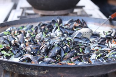Kazanda midyeler var. Yemek katı. Sokak yemeği. Kabuklu midyeler. Sosta pişirilmiş midyeler, kazan. Deniz ürünleri tabağı pişiriyorum.