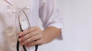 Elinde steteskop olan doktor ya da hemşire. Tıp ve sağlık konsepti. Steteskoplu beyaz önlüklü çocuk doktoru. Kadın, tıbbi ve kardiyak izleme cihazı, beyaz arka plan. Tedavi