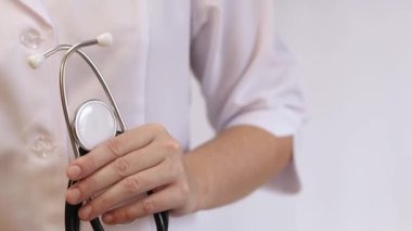 Elinde steteskop olan doktor ya da hemşire. Tıp ve sağlık konsepti. Steteskoplu beyaz önlüklü çocuk doktoru. Kadın, tıbbi ve kardiyak izleme cihazı, beyaz arka plan. Tedavi