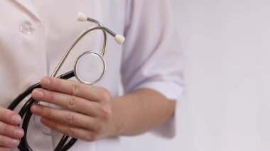 Elinde steteskop olan doktor ya da hemşire. Tıp ve sağlık konsepti. Steteskoplu beyaz önlüklü çocuk doktoru. Kadın, tıbbi ve kardiyak izleme cihazı, beyaz arka plan. Tedavi