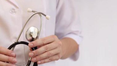Elinde steteskop olan doktor ya da hemşire. Tıp ve sağlık konsepti. Steteskoplu beyaz önlüklü çocuk doktoru. Kadın, tıbbi ve kardiyak izleme cihazı, beyaz arka plan. Tedavi