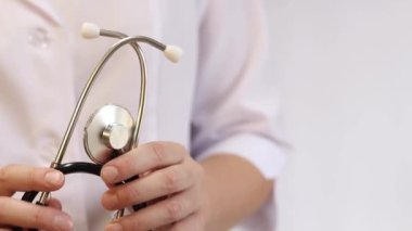 Elinde steteskop olan doktor ya da hemşire. Tıp ve sağlık konsepti. Steteskoplu beyaz önlüklü çocuk doktoru. Kadın, tıbbi ve kardiyak izleme cihazı, beyaz arka plan. Tedavi
