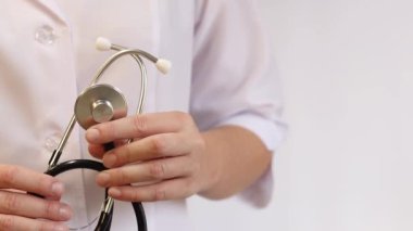 Elinde steteskop olan doktor ya da hemşire. Tıp ve sağlık konsepti. Steteskoplu beyaz önlüklü çocuk doktoru. Kadın, tıbbi ve kardiyak izleme cihazı, beyaz arka plan. Tedavi