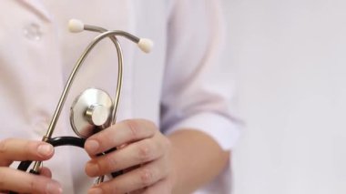Elinde steteskop olan doktor ya da hemşire. Tıp ve sağlık konsepti. Steteskoplu beyaz önlüklü çocuk doktoru. Kadın, tıbbi ve kardiyak izleme cihazı, beyaz arka plan. Tedavi