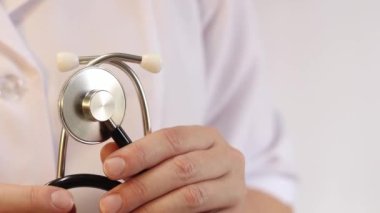Elinde steteskop olan doktor ya da hemşire. Tıp ve sağlık konsepti. Steteskoplu beyaz önlüklü çocuk doktoru. Kadın, tıbbi ve kardiyak izleme cihazı, beyaz arka plan. Tedavi