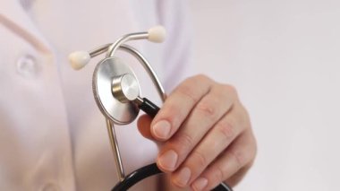 Elinde steteskop olan doktor ya da hemşire. Tıp ve sağlık konsepti. Steteskoplu beyaz önlüklü çocuk doktoru. Kadın, tıbbi ve kardiyak izleme cihazı, beyaz arka plan. Tedavi