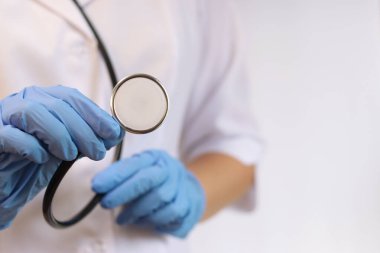 Steteskoplu doktor ya da hemşire. Tıp ve sağlık konsepti. Steteskoplu beyaz önlüklü çocuk doktoru. Kadın, tıbbi ve kardiyak izleme cihazı, beyaz arka plan. Tedavi