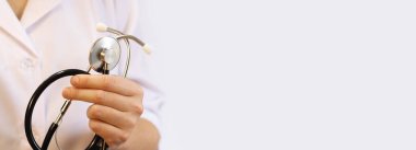 Elinde steteskop olan doktor ya da hemşire. Tıp ve sağlık konsepti. Steteskoplu beyaz önlüklü çocuk doktoru. Kadın, tıbbi ve kardiyak izleme cihazı, beyaz arka plan. Boşluğu kopyala