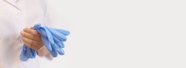 Eldivenli doktor ya da hemşire. Tıp ve sağlık konsepti. Beyaz önlüklü çocuk doktoru. Kadın doktor, beyaz bir geçmişi var. Uzayı kopyala Aile doktoru. Lateks mavi eldivenli ellerin yakın çekimi