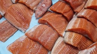 Kırmızı somon ya da alabalık bir mağazada vitrinde satılır. Süpermarketteki balık reyonunda. Lezzetli ve sağlıklı deniz ürünleri. Soğutulmuş balık soğutmalı tezgahın üzerinde yatıyor. Taze balık yakın plan.