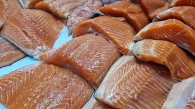 Kırmızı somon ya da alabalık bir mağazada vitrinde satılır. Süpermarketteki balık reyonunda. Lezzetli ve sağlıklı deniz ürünleri. Soğutulmuş balık soğutmalı tezgahın üzerinde yatıyor. Taze balık yakın plan.