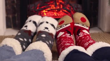 Şöminenin yanındaki Noel çoraplı ayak manzaralı ilk kişi. Sıcak Noel çorapları içinde bir çift ayak şöminenin yanında ısınıyor. Noel atmosferi. Kış, Yeni Yıl konsepti