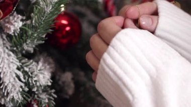 Kadınların elleri ağaca oyuncak asıyor. Yeni yıla hazırlanmak, dekorasyon, Noel ağacı baloları. Bayram kutlaması için kadınların evi hazırlaması. Yeni Yıl ve Noel
