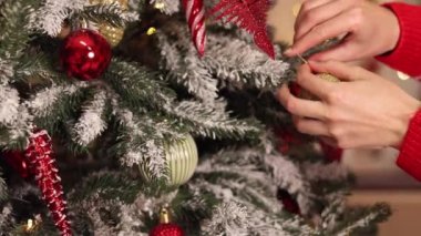 Kadınların elleri ağaca oyuncak asıyor. Yeni yıla hazırlanmak, dekorasyon, Noel ağacı baloları. Bayram kutlaması için kadınların evi hazırlaması. Yeni Yıl ve Noel