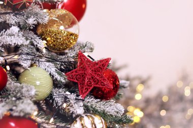 Noel ağacı süslemeleri, ağaçtaki yıldız ve toplar, yakın plan. Yeni yıl ağacının dekoru. - Mutlu yıllar. Şenlik havası. Altın parlak top. Yeni Yıl ve Noel