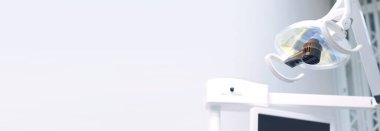 Lamba dişçinin ofisinde, yakın plan. Diş aletleri, lamba. Uzayı kopyala Dişçinin ofisinde ayarlanabilir ışıklandırma. Lamba, dişçi koltuğunun üstünde hareket edebilen bir standın ışığı. Işıklandırma