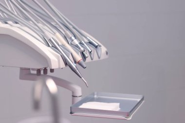 Dişçi aletleri, ortodontist işyeri. Diş hekimliği. Diş tedavisi için bir takım aletler. Klinikteki diş teçhizatı, yakın plan. Aletler. Ağız temizliği kavramı. Dişçinin işyeri, hafif ofis.