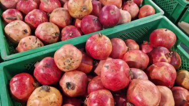 Süpermarketteki bir kutuda olgun nar meyveleri. Markette ya da markette plastik bir kutuda nar meyveleri. Doğal nar yığını, yakın plan.