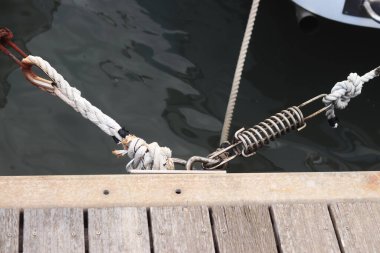 Demirleme kalesi, bir yat iskelesinde bağlama düğümü. Yatın bağlama ipleri diz kapağına bağlı. Halatları bağlamak için iskelede diz çökün. Bağlama ve bağlama ipleri için diz çökün