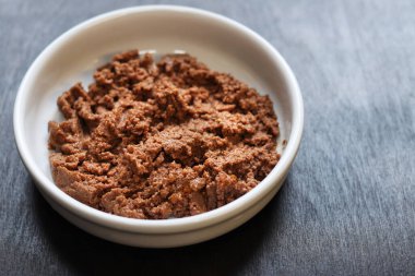 Kedi maması, börek, yan görüş. Siyah arka planda yuvarlak beyaz bir tabakta konserve hayvan yiyeceği. Evcil kediler için lezzetli ve sağlıklı yiyecekler. Bir porsiyon ıslak yemek, tabakta kedi için yumuşak börek. Boşluğu kopyala