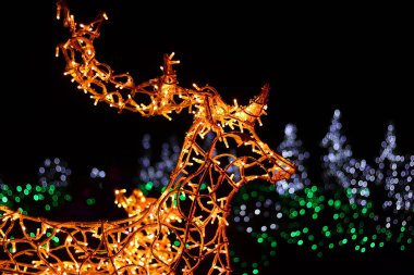 Motizhyn, Ukraine - December 29, 2024: Deer made of garlands, close-up. Deer head made of glowing bulbs at night, festive lights for the new year, blur. Glowing electric decorations for Christmas clipart