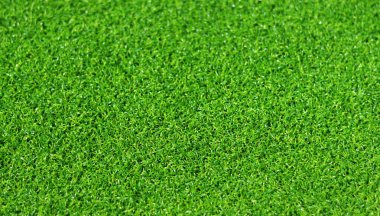 Yapay yeşil çimen paspası, seçici odaklanma. Suni çim, yapay liflerden yapılmış yüzey. Yeşil çimen dokusu. Kısa yapay golf sahası