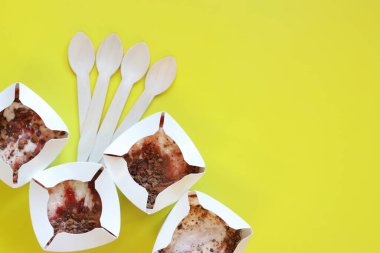 Kyiv, Ukrayna - 2 Ocak 2025: McDonald 's McFlurry dondurması, üst manzara. McFlurry sarı arka planda fotokopi alanı ile. Kartondan tek kullanımlık bardaklarda dondurma. McDonald 's restoranından yemek.