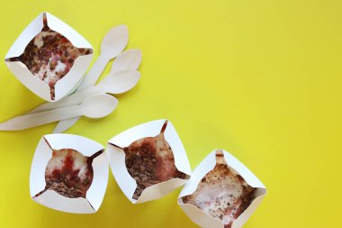 Kyiv, Ukrayna - 2 Ocak 2025: McDonald 's McFlurry dondurması, üst manzara. McFlurry sarı arka planda fotokopi alanı ile. Kartondan tek kullanımlık bardaklarda dondurma. McDonald 's restoranından yemek.