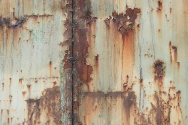Eski paslı metal yüzey, boyası soyulmuş ve yağmurdan kalan kirli çizgiler var. Çatlak boya dokusu. Arka plan, doku. Paslı demirin aşınması. Paslı ve eski metalin üzerindeki boyalar soyuluyor.