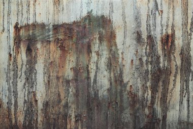 Eski paslı metal yüzey, boyası soyulmuş ve yağmurdan kalan kirli çizgiler var. Çatlak boya dokusu. Arka plan, doku. Paslı demirin aşınması. Paslı ve eski metalin üzerindeki boyalar soyuluyor.