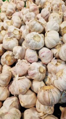 Sarımsak süpermarkette yakındır. Marketteki plastik yeşil kutuda bir sürü sarımsak var. Çiftçi pazarında yeşil plastik kutuda sarımsak. Dükkanda satılık sarımsak. Satılık taze ürünlerin görüntüsü