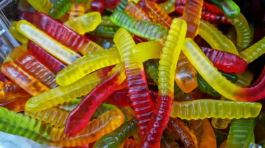 Renkli jelibon solucanları. Jelibon şekerlemelerine yakın çekim. Dükkandaki şeker reyonunda. Parlak renkli jelibon çiğneme şekeri. Tatlılar