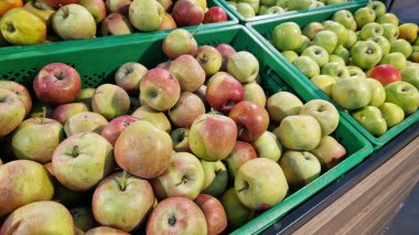 Süpermarkette satılık elmalar. Olgun sulu elmalar seçici bir odaklanma ile yakın çekim. Meyveler. Mağazada satılık bir yığın elma. Süpermarket tezgahında çeşitli taze elmalar.