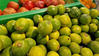 Seçici odaklı limonlar. Mağazada satılık tonlarca lezzetli limon. Taze ürünlerin çeşitliliği. Süpermarkette satılık limonlar. Olgun, sulu, yeşil meyveli C vitamini.