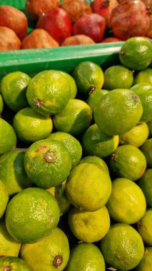 Seçici odaklı limonlar. Mağazada satılık tonlarca lezzetli limon. Taze ürünlerin çeşitliliği. Süpermarkette satılık limonlar. Olgun, sulu, yeşil meyveli C vitamini.