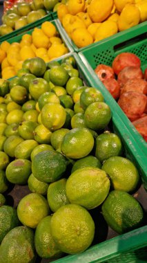 Seçici odaklı limonlar. Mağazada satılık tonlarca lezzetli limon. Taze ürünlerin çeşitliliği. Süpermarkette satılık limonlar. Olgun, sulu, yeşil meyveli C vitamini.