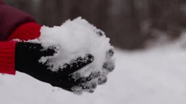 Karı tutan kadın elleri. Kış. Kadının elleri temiz kar tutarken yakın plan. Kışın sıcak siyah eldivenli kız. Kışın dışarıda vakit geçirmek. Soğuk bir hava. İnsan doğayla etkileşimi