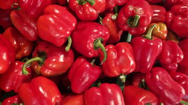 Mağazadaki tezgahta kırmızı biber. Süpermarkette olgun biberler, yakın plan. Yemek pişirmek için. Bir grup taze kırmızı biber. Sağlıklı beslenme ve vejetaryenlik. Markette sebzeler