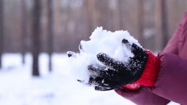 Karı tutan kadın elleri. Kış. Kadının elleri temiz kar tutarken yakın plan. Kışın sıcak siyah eldivenli kız. Kışın dışarıda vakit geçirmek. Soğuk bir hava. İnsan doğayla etkileşimi